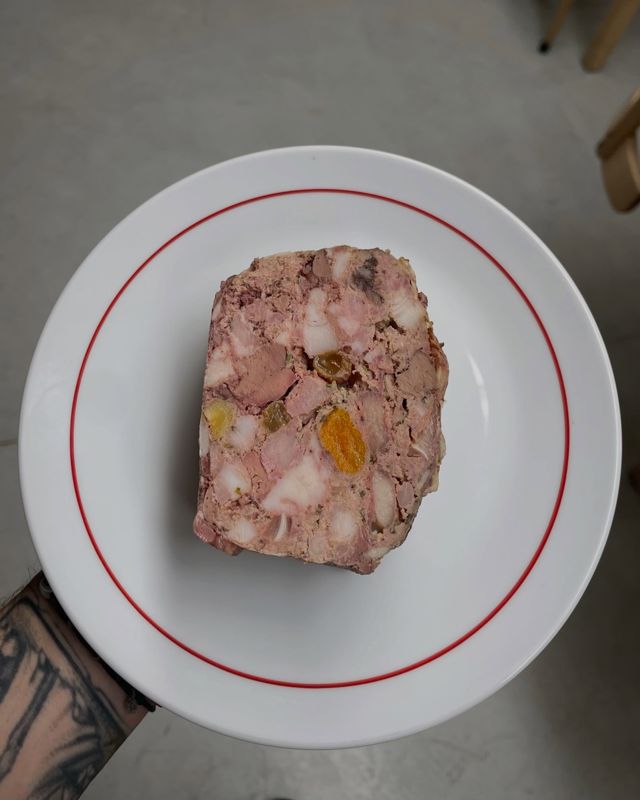 Terrina de cerdo en plato de borde rojo